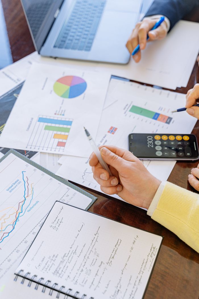 services-05 A close-up of businesspeople analyzing financial data and charts during a meeting.